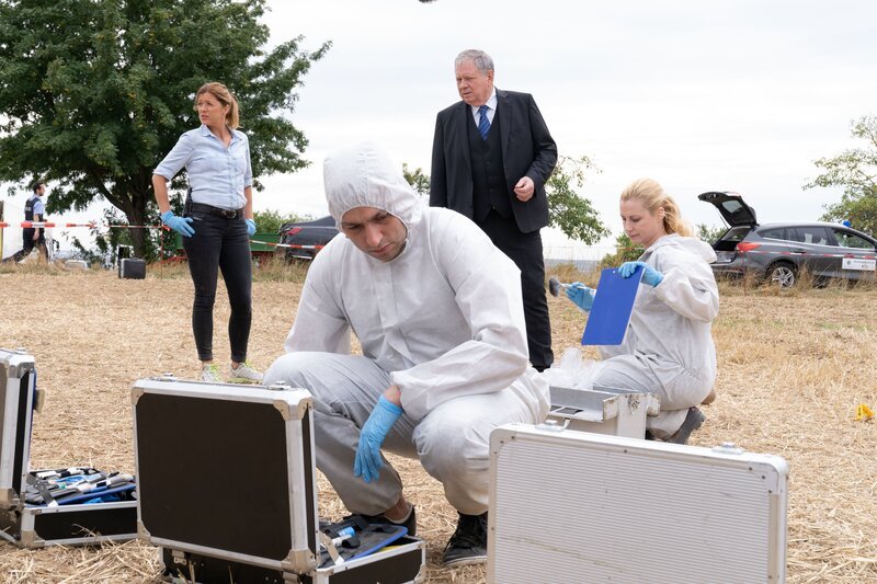 Hauptkommissarin Kerstin Klar (Fiona Coors, l.), Oberstaatsanwalt Bernd Reuther (Rainer Hunold, 2.v.r.) und Dr. Judith Engel (Astrid Posner, r.) haben einen neuen Fall: Landwirt Thomas Dittmann ist unter mysteriösen Umständen auf einem Feld ums Leben gekommen. – Bild: ZDF und Andrea Enderlein