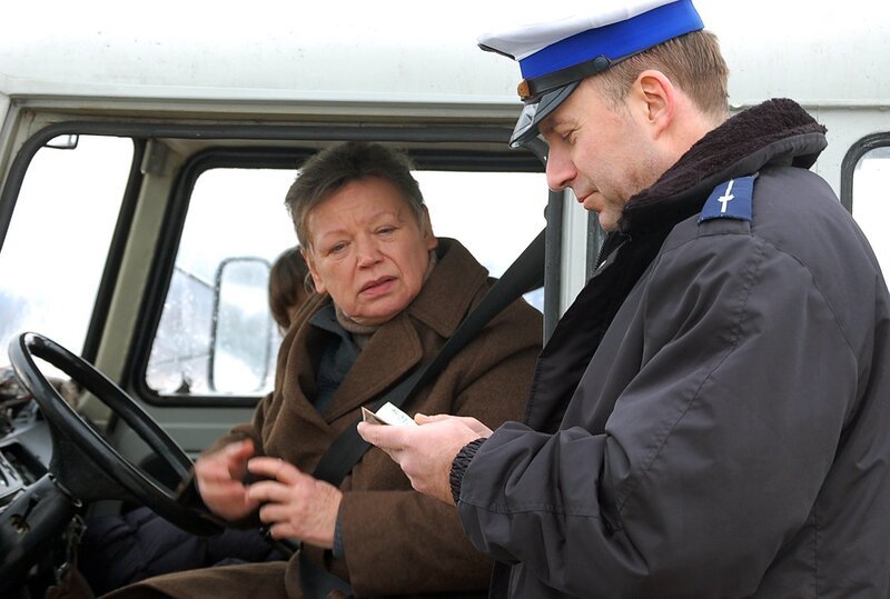 „Was, Sie sind in Olsztyn geboren? Ich auch!“ – sagt der Polizist (Konrad Pawicki) zu Lene (Ursula Werner) während einer Kontrolle. Der Blinker am Barkas ist kaputt und bei der Gelegenheit fällt auch Knäcke (Leon Seidel) als blinder Passagier aus dem Auto. – Bild: rbb/​Piotr Majorkiewicz