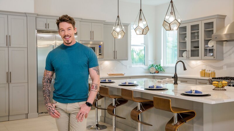 Host David Bromstad poses for a photo in this modern kitchen in Orlando, Florida, as seen on Lottery Dream Home. (portrait) – Bild: HGTV /​ Emilee Ramsier