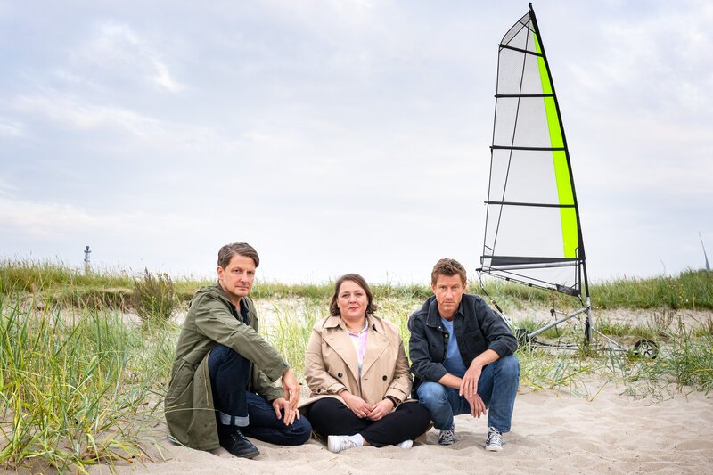 Ein tödlicher Ausflug mit dem Strandsegler – Wolfgang Habedank (Holger Stockhaus, l.), Melanie Harms (Tina Pfurr, M.) und Henk Cassens (Maxim Mehmet, r.) zweifeln an der Unfalltheorie. – Bild: ZDF und Michael Kötschau