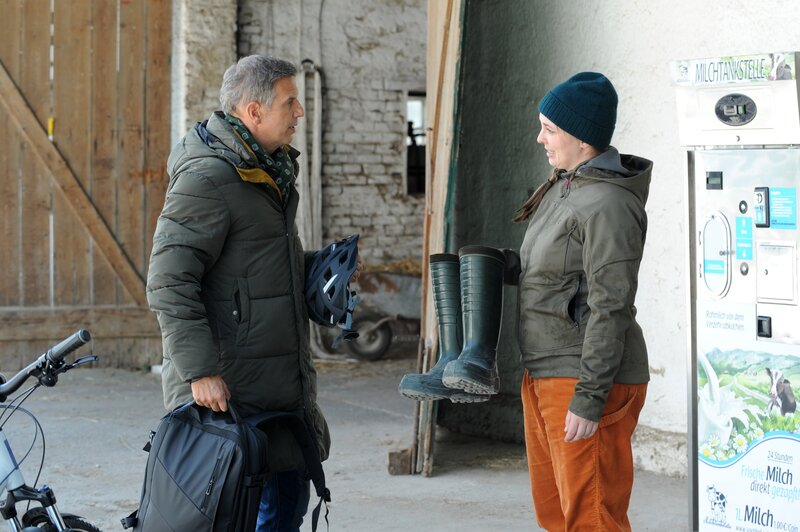 Sophia (Patricia Freund) will Winkler (Florian Stadler) für den Wahlkampf in Sachen Landwirtschaft fit machen, indem er ihr bei der Hofarbeit hilft. – Bild: Marco Orlando Pichler /​ BR