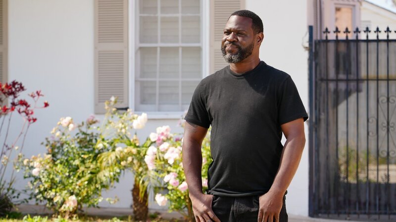 Kayland Brock standing outside of client house – Bild: Warner Bros. Discovery, Inc. or its subsidiaries and affiliates.