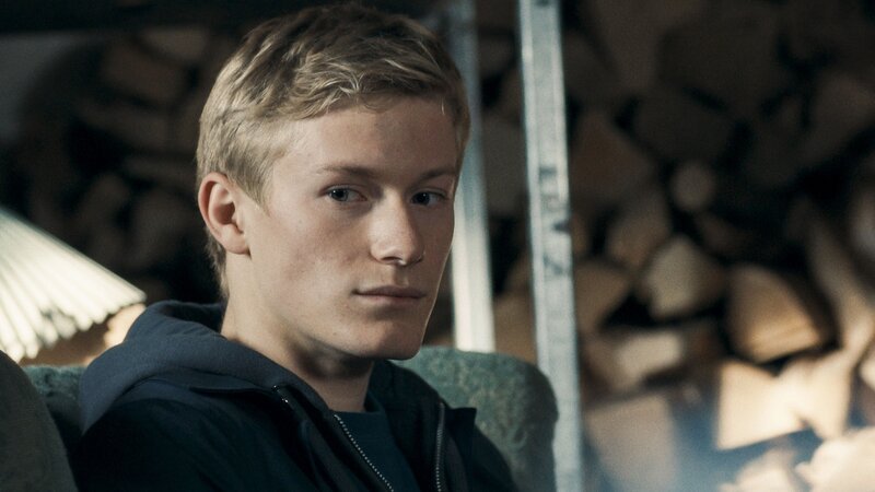 Lasse (Albert Rosin Harson) überlegt, ob er Floras Wunsch erfüllen und ein Konzert im Studentenwohnheim geben soll. – Bild: BR/​TV 2 Denmark/​Cosmo Film