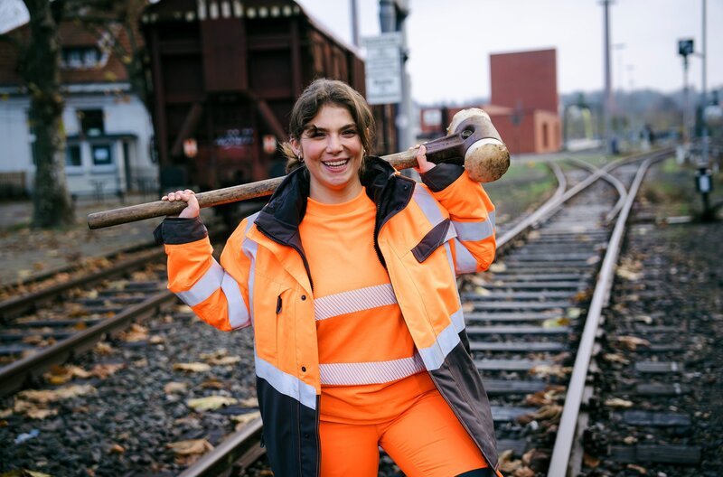 Sie sind Azubis und sie lieben ihren Job. Was wird sie diesmal auf den Baustellen erwarten? Oft wachsen die Auszubildenden über sich hinaus, manchmal geht auch alles schief. Zum Glück sind ihre Ausbilder, die Meister und Gesellen, eng an ihrer Seite. Und auch ihre Freunde und alle Familienmitglieder fiebern mit. – Azubine Burcu beim Gleisbau. – Bild: WDR/​Ben Knabe