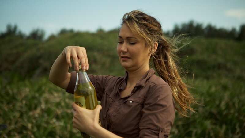Jess öffnet eine Flasche Habushu am Maeda Point – Bild: Warner Bros. Discovery, Inc. or its subsidiaries and affiliates