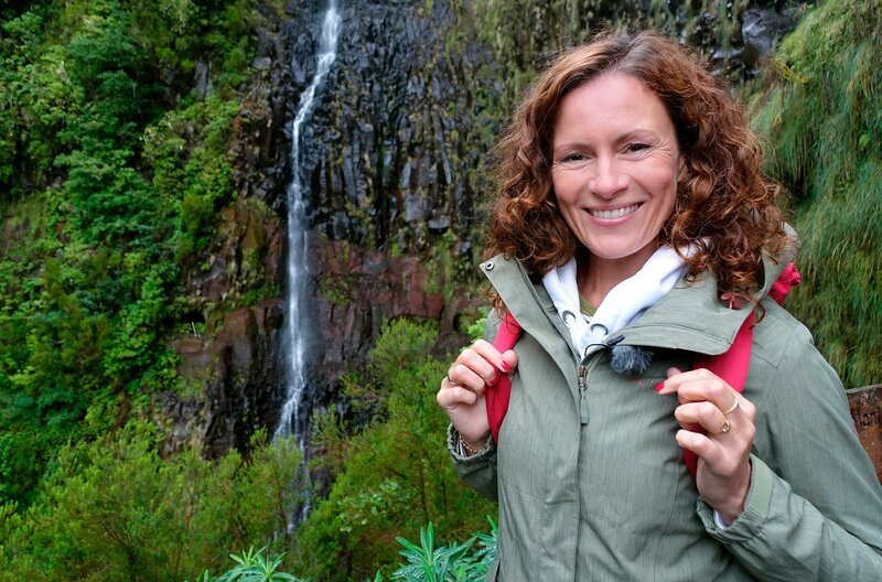Für die Wanderung durch den uralten Lorbeerwald und ins Reich der Wasserfälle braucht Anne Willmes einen Regenmantel. – Bild: WDR/​Tobias Spelz