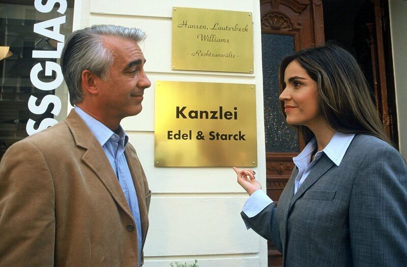 Felix (Christoph M. Ohrt, l.) lässt ein neues Kanzleischild anbringen, um das der Konkurrenz optisch zu überbieten. Sandra (Rebecca Immanuel, r.) findet das ziemlich albern … – Bild: SAT.1 /​ Hardy Spitz Eigenproduktionsbild frei