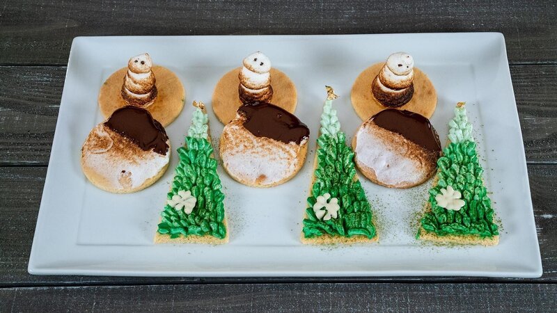 Contestant Justin Iso’s dish Tree, Sable Breton with Fromage Creme with Yuzu and Dusted with Matcha Topped with Chocolate Snowflake and Gold Leaf, Snowman S’mores Cookie, Same Dough with Italian Meringue Snowman and Melted Chocolate, during the first round, The Decorating Challenge, „O Come All Ye Ombre“, as seen on Christmas Cookie Challenge, Season 2. – Bild: Television Food Network, G.P. All Rights Reserved.