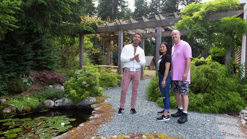 David Bromstad, left, shows Tuk and Brian Kutz the backyard garden in a home in Coupeville, WA on Whidbey Island as seen on My Lottery Dream Home. – Bild: Discovery, Inc. /​ Ron Wurzer /​ Getty Images