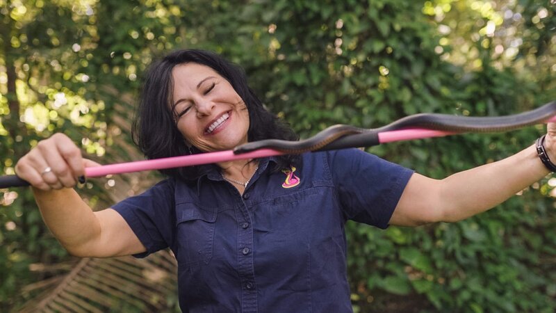 Snake Catcher Julia with venamouse snake (red bellied back snake) – Bild: Warner Bros. Discovery