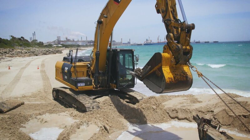 Luke Purdy and his co-workers use a dredger to dig the vessel free on the beach. – Bild: DMAX