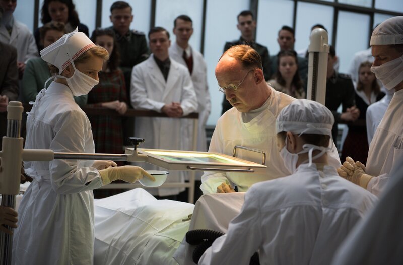 Prof. Sauerbruch (Ulrich Noethen, 3.v.r.) rettet in einem dramatischen Eingriff das Leben von einem Jungen, der von einem Blindgänger schwer verwundet wurde. Seine Frau Margot (Luise Wolfram, 2.v.r.) und Schwester Christel (Frida-Lovisa Hamann, l.) assistieren. – Bild: ARD/​Julie Vrabelova