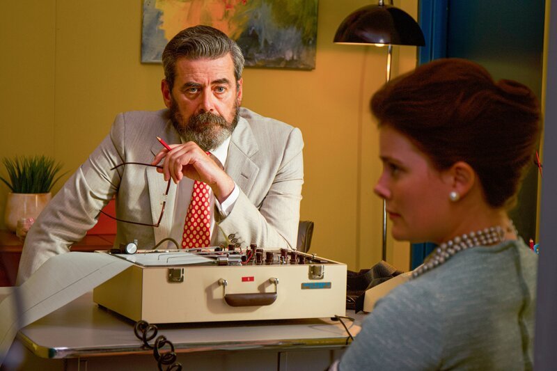 Ein Mann sitzt an einem Tisch und beobachtet eine Frau. – Bild: THE HISTORY CHANNEL /​ A+E Networks