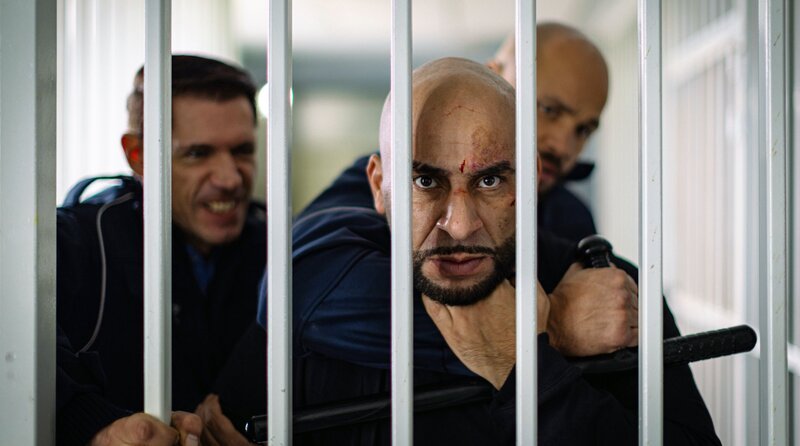 Hassan „Pittbull“ (Veysel Gelin) flippt aus und muss von den Wärtern zurückgehalten werden. – Bild: ARD Degeto Film/​Pantaleon Films GmbH/​Mirza Odabasi
