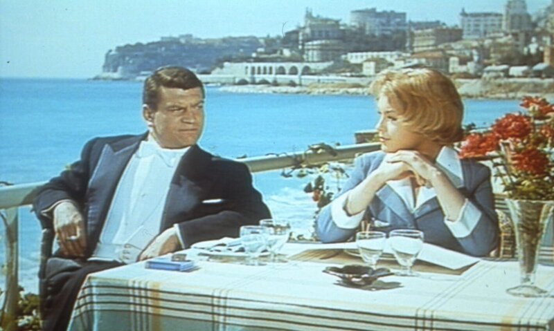 Der Rennfahrer Pierre Chaillot (Henri Vidal) will einfach nicht glauben, dass die schöne Unbekannte (Romy Schneider), die immer wieder bei ihm auftaucht, sein Schutzengel ist. – Bild: Heimatkanal Der Rennfahrer Pierre Chaillot (Henri Vidal) will einfach nicht glauben, dass die schöne Unbekannte (Romy Schneider), die immer wieder bei ihm auftaucht, sein Schutzengel ist. – Bild: Heimatkanal