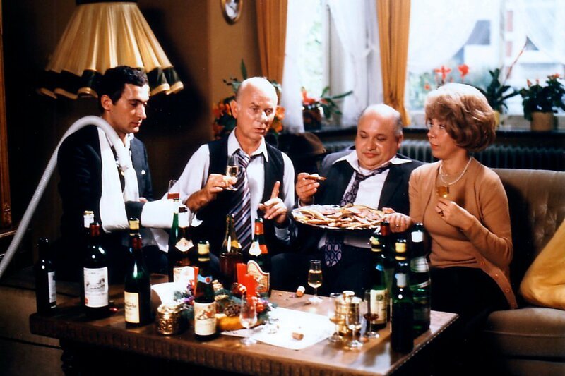 Vertreterbesuch – Normalerweise werden Vertreter von deutschen Hausfrauen gleich an der Haustür abgefertigt. Aber in der Vorweihnachtszeit kann es passieren, dass eine unvoreingenommene Hausfrau das traurige Los von Außendienstmitarbeitern mit Imbiss und Umtrunk mildert. Frau Hoppenstedt jedenfalls fühlt sich wohl im Kreis von drei Herren aus der Staubsauger-, Wein- und Versicherungsbranche. – Bild: Radio Bremen – Foto Do Leibgirries