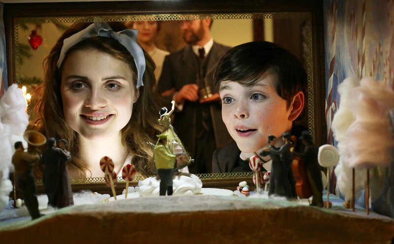 Marie Stahlbaum (Mala Emde) und Fritz Stahlbaum (Leonard Seyd) schauen erstaunt in die Zuckerwelt. (Im Hintergrund: die Eltern Frau Stahlbaum (Brigitte Hobmeier), Vater Stahlbaum (Jürgen Tonkel). – Bild: MDR/​RB/​Christian Schulz