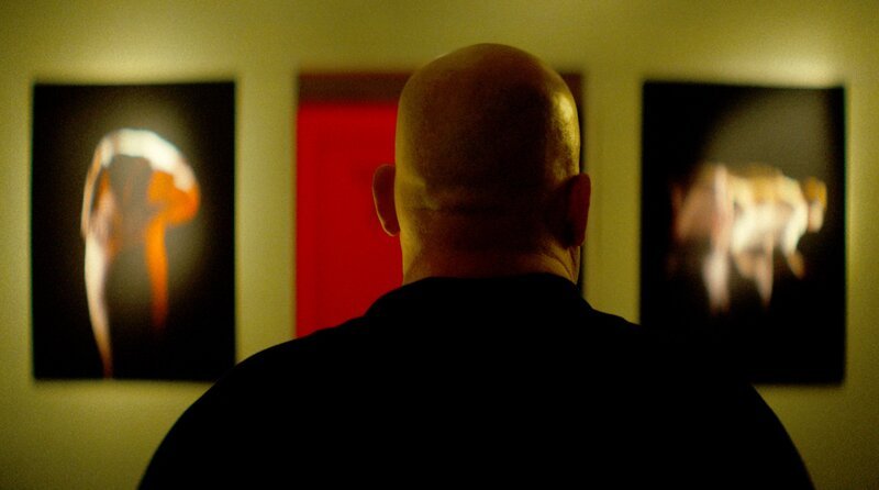 Fero (Hakan Orbeyi) steht in der Galerie und schaut sich die Bilder seines Bruders an. – Bild: SWR