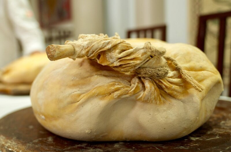 Shakuli ist Frischkäse, der zusammen mit einem großen Stück Wacholderholz in ein Schafsfell eingebunden wird. Der Wacholder macht den Käse aromatisch und haltbar. – Bild: Oliver Kratz