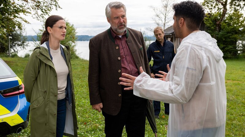Aufgeregt erklärt Dominik Meis (Younes Tissinte, r.) den Hauptkommissaren Beck (Michaela Weingartner, l.) und Stadler (Dieter Fischer, 2.v.l.) sowie Polizeihauptmeister Mohr (Max Müller, 2.v.r.), wie er zufällig am Seeufer einen Toten gefunden hat. – Bild: ZDF und Linda Gschwentner