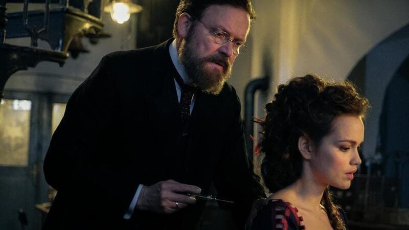 Robert Koch (Justus von Dohnányi) erprobt sein neuartiges Tuberkulose-Heilmittel auch an seiner Geliebten Hedwig (Emilia Schüle) – er spritzt ihr Tuberkulin. – Bild: MDR/​Nik Konietzny