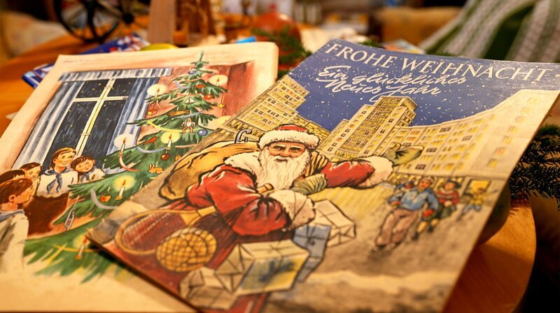 Der Weihnachtsmann in der Berliner Stalinallee und singende Pioniere um einen Weihnachtsbaum: In den 50er Jahren versuchte die DDR-Führung das Weihnachtsfest politisch zu vereinnahmen. – Bild: NDR Der Weihnachtsmann in der Berliner Stalinallee und singende Pioniere um einen Weihnachtsbaum: In den 50er Jahren versuchte die DDR-Führung das Weihnachtsfest politisch zu vereinnahmen. – Bild: NDR