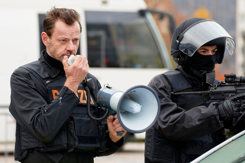 Geiselnahme in einem Cafe: Der Einsatzleiter (Lars Wellings) verteilt seine Leute vor dem Cafe und nimmt die Forderungen der Geiselnehmer entgegen. – Bild: MG RTL D /​ Guido Engels