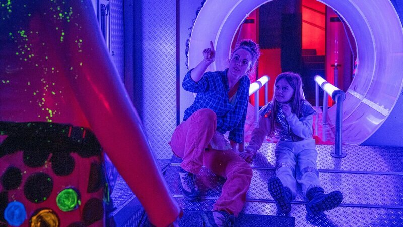 Nachdem der Chef eines Indoor-Spielplatzes getötet wurde, konzentrieren sich die Ermittlungen auf die dortige Szenografin Emily Hellwig (Julia E. Lenska, l.). Sie stand im Konflikt mit ihrem Chef, weil der ihr einen Arbeitgebernachweis verweigerte, den die alleinerziehende Frau dringend gebraucht hätte, um eine Wohnung mit ihrer Tochter Mia (Komparsin, r.) anzumieten. – Bild: ZDF und MARKUS_FENCHEL