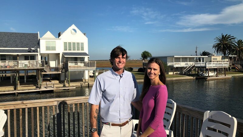 Contributors Chris Henry (L) and Lauren Henry (R) smile for the camera as they check out the waterfront deck while touring Pam Skies, as seen on HGTV’s Beachfront Bargain Hunt. – Bild: Discovery, Inc.