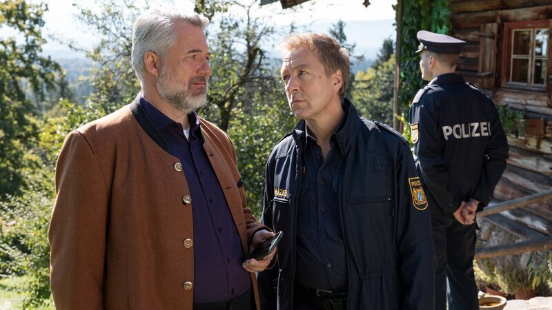 Hauptkommissar Stadler (Dieter Fischer, l.) und Polizeihauptmeister Mohr (Max Müller, r.) besprechen die ersten Ermittlungsergebnisse. Polizist im Hintergrund: Komparse. – Bild: ZDF und Linda Gschwentner