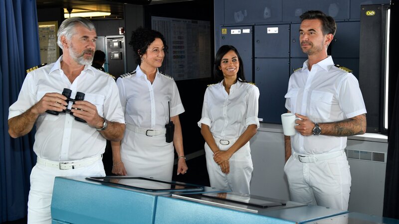 Kapitän Max Parger (Florian Silbereisen, r.) schwelgt in Erinnerungen. Hanna (Barbara Wussow, 2.v.l.), Dr. Jessica Delgado (Collien Ulmen-Fernandes, 2.v.r.) und Staff-Kapitän Martin Grimm (Daniel Morgenroth, l.) hören ihm gespannt zu. – Bild: ZDF und Dirk Bartling
