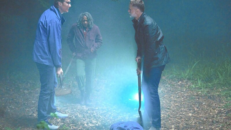 Greg (Stephen Merchant, l.), Myrna (Clare Perkins, M.) und John (Darren Boyd, r.) wollen die Leiche von Smiler verschwinden lassen. – Bild: ZDF und Simon Ridgway