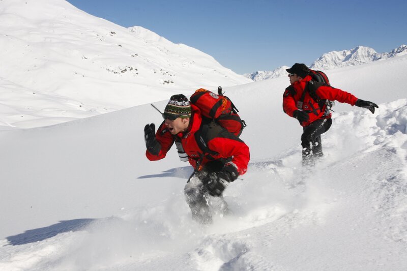 Bei dem Versuch, das Spenderherz im abgestürzten Wrack des Flugzeuges zu finden, geraten Martin Gruber (Hans Sigl, r.) und sein Bruder Hans (Heiko Ruprecht, l.) in eine Lawine. Mit letzter Kraft fliehen sie vor den herabstürzenden Schneemassen. – Bild: ZDF/​Erika Hauri