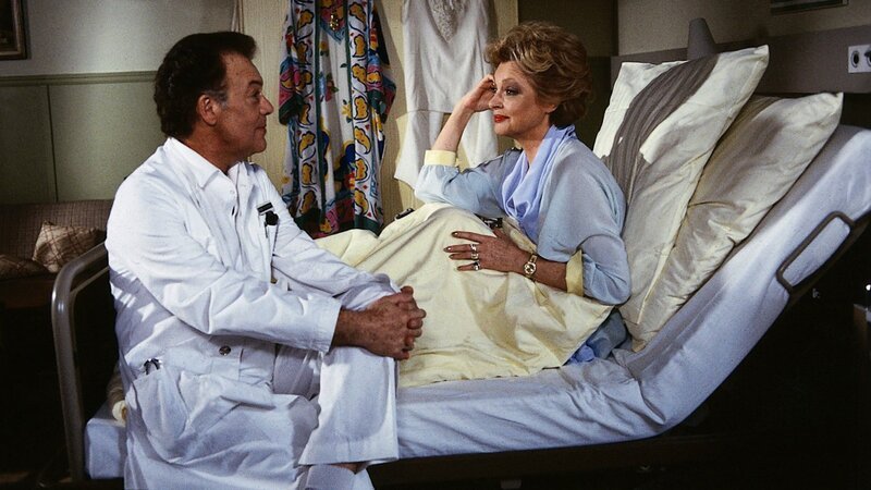 Die exzentrische Vanessa Bodenstedt (Nadja Tiller, r.) möchte ungeteilte Aufmerksamkeit und will nur von Prof. Brinkmann (Klausjürgen Wussow, l.) persönlich behandelt werden. – Bild: ZDF und Thomas Waldhelm