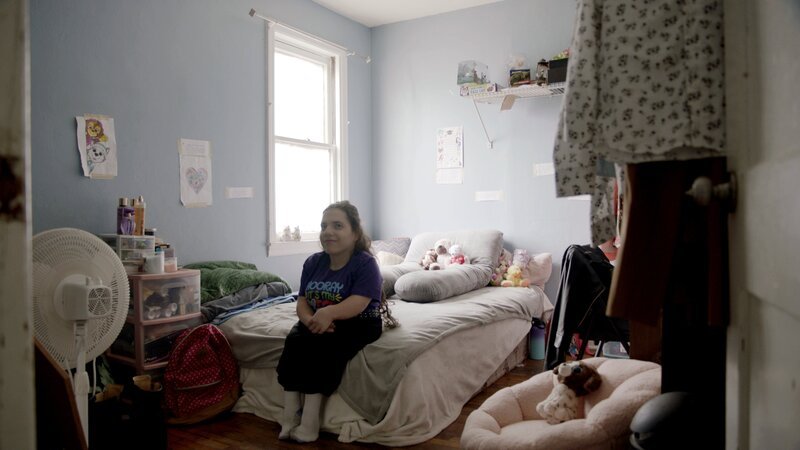 Natalia sits on her bed the morning of her adoption day. – Bild: Warner Bros. Discovery, Inc. or its subsidiaries and affiliates