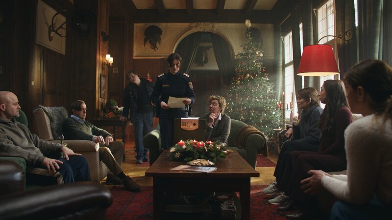 Im festlich geschmückten Wohnzimmer wird ermittelt. Von links: Jochen Dahlmann (Jürgen Vogel), Leander Dahlmann (Heino Ferch), Polizist Oliver (Dominic Marcus Singer), Polizistin Greta (Noëmi Krausz), Viktoria Dahlmann (Margarita Broich), Therese Dahlmann (Anja Kling), Emma (Carol Schuler) und Susa Dahlmann (Ulrike C. Tscharre) – Bild: Maximilian Hoever /​ ZDF und Maximilian Hoever