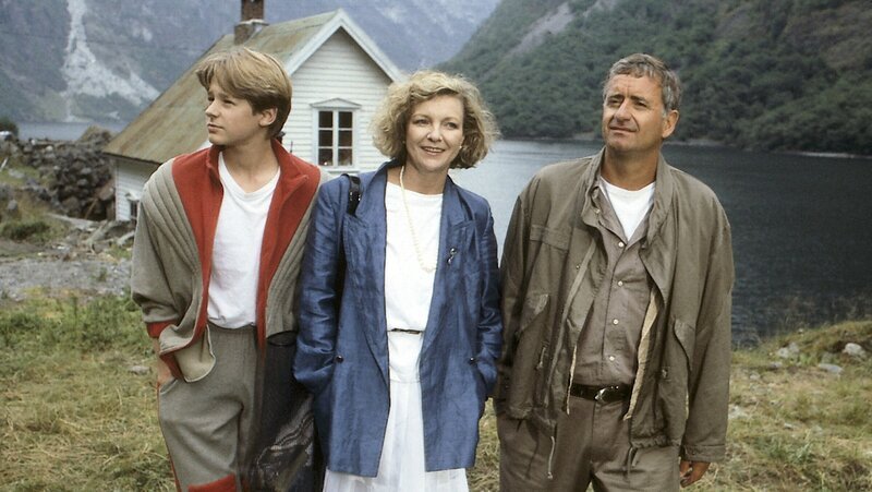 Chiefdriller Peter Pacard (Peter Bongartz, r.) hatte mit seiner Frau Katrin (Gila von Weitershausen, M.) und seinem Sohn Patrik (Hendrik Martz, l.) einen ruhigen Urlaub in einem norwegischen Fjord vor. Lachse wollte er fangen, mit seiner Frau Tennis spielen und mit dem Jungen den Modellhubschrauber fliegen lassen. Statt dessen gerieten sie in eine turbulente Agentenschlacht um eine geheimnisvolle Formel, so dass ihr Haus von den Sicherheitsbehörden besetzt wird und sie ziemlich ratlos das Geschehen verfolgen, das sie selbst immer mehr bedroht. – Bild: ZDF und Jürgen & Thomas