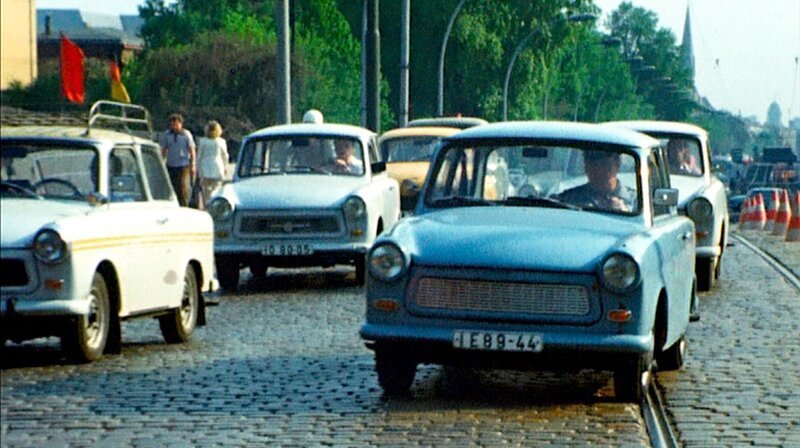 Autos wie Trabant, Wartburg, Ford Taunus oder VW Käfer sind früher so etwas wie ein Familienmitglied und die Städte scheinen jedes Jahr ein bisschen autogerechter zu werden. Der Film blickt zurück auf kuriose und dramatische Themen, die Autofahrer von den 1950ern bis in die 1990er Jahre bewegt haben wie die Ölkrise, Smog, Tempolimit, Politessen, Parkhäuser oder Drive-In-Bankfilialen. – Trabant im Verkehr. – Bild: rbb/​DRA