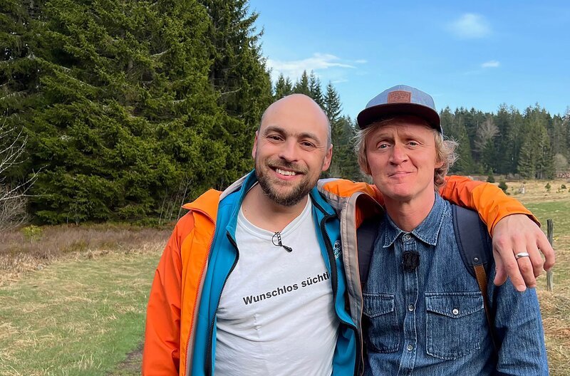 Es war einmal ein Musiker. Er nannte sich Max Mutzke. Von den Alpen bis an die Nordsee lauschte man gern seiner wohlklingenden Stimme. Gefeiert und umjubelt reiste er durch die Landen, doch träumte er nur von der Heimat. Tief im schwarzen Zauberwald war er zu Hause und lebte zusammen mit Zwergen, Wildschweinen und Gandalf, dem Grauen. Als Loipenbotschafter raupte er Pisten oder laichte im Schnee. Der Wald bot ihm alles im Überfluss. Klopfte er auf Holz, sprießte sogleich der reine Gerstensaft aus dem Mutterboden. Max hätte glücklicher kaum sein können. Und doch fehlte ihm was. Er sehnte sich nach seinem Traumprinzen. Vor seinen Augen zeichnete sich stets das gleiche Bild. Eine Wanderung mit ihm. Eine Kurzstrecke mit Pierre M. Krause. – Bild: SWR/​dibido /​ ZDF