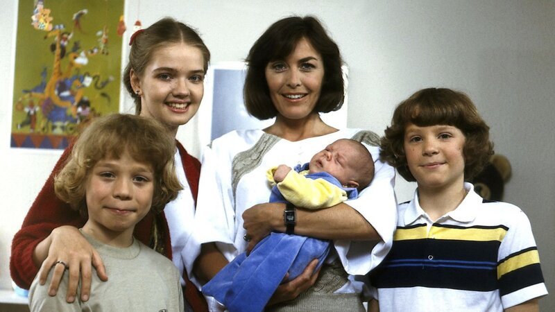 Die glückstrahlende Angi (Thekla Carola Wied, 2. v. r.) mit ihren älteren Kindern Markus (Timmo Niesner, l.), Tanja (Julia Biedermann, 2. v. l.) und Tom (Tarek Helmy, r.) wobei natürlich die jüngste, Franziska, nunmehr im Mittelpunkt steht. – Bild: ZDF und Nova Film