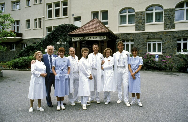 Das Personal der „Schwarzwaldklinik“ (von links nach rechts): Oberschwester Hildegard (Eva Maria Bauer), Verwaltungsdirektor Alfred Mühlmann (Alf Marholm), Schwester Ina (Gaby Fischer), Dr. Gerd Wolter (Franz Rudnick), Dr. Katarina Gessner (Ilona Grübel), Prof. Klaus Brinkmann (Klausjürgen Wussow), Schwester Christa (Gaby Dohm), Dr. Udo Brinkmann (Sascha Hehn) und Schwester Elke (Barbara Wussow). – Bild: ZDF/​Thomas Waldhelm