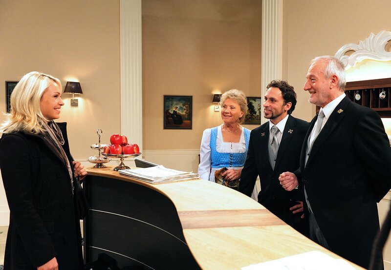 Alfons (Sepp Schauer, r.), Hildegard (Antje Hagen, 2.v.l.) und Portier Max (Roland Seibert, 2.v.r.) sind hocherfreut, als Gold-Biathletin Magdalena Neuner (l.) für ein paar Tage im Fürstenhof eincheckt. – Bild: ARD/​Ann Paur