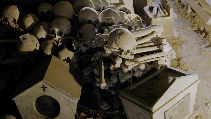 Das Bild zeigt Knochen und Schädel auf dem Friedhof Fontanelle (Cimitero delle Fontanelle) in Neapel, Italien. – Bild: CuriosityStream-Inc.