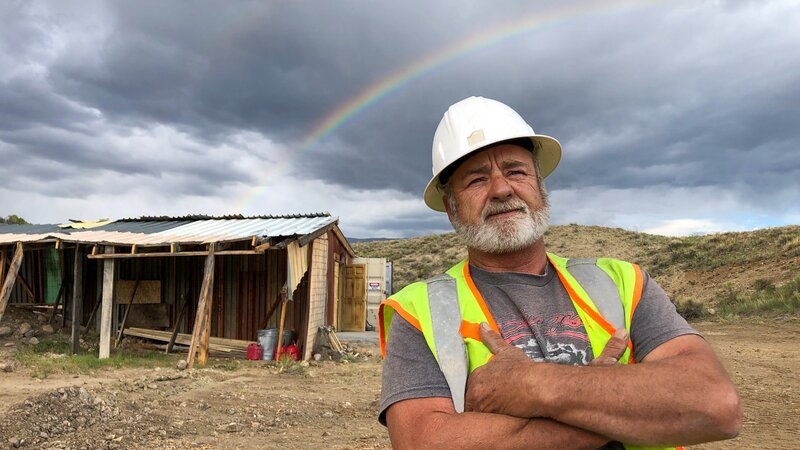 Hero shot of Jesse Goins. Arms crossed with a rainbow in the background – Bild: Discovery Communications, LLC