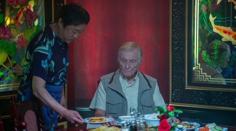 Der ehemalige DDR-Funktionär Herr Schimke (Hermann Beyer, re.) prüft, ob das Restaurant den Ansprüchen seiner Ausflugsgruppe entspricht. – Bild: ARD Degeto Fim/​UFA Fiction GmbH/​Oliver Vaccaro