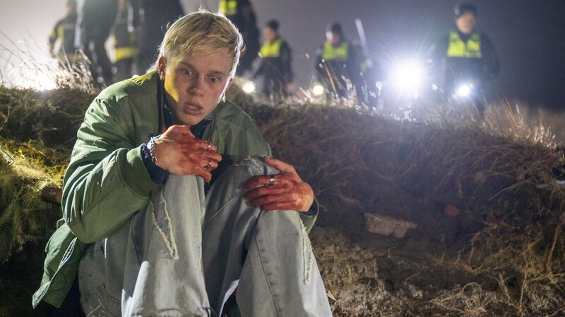 Marvin Claudius (Noah Kraus) wird blutverschmiert bei einer Suchaktion gefunden, nachdem er seiner Angreiferin – der Mutter seines verstorbenen Freundes -entkommen konnte. Der 15-jährige ist offensichtlich traumatisiert von dem Vorfall. – Bild: Michael Ihle /​ ZDF