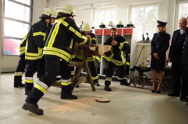 Die Wangener meistern das Baumstammsägen mit Bravour. Von links: Trixi Preissinger (Doreen Dietel) und Pfarrer Kurz (Hans Stadelbauer). – Bild: BR/​Jo Bischoff