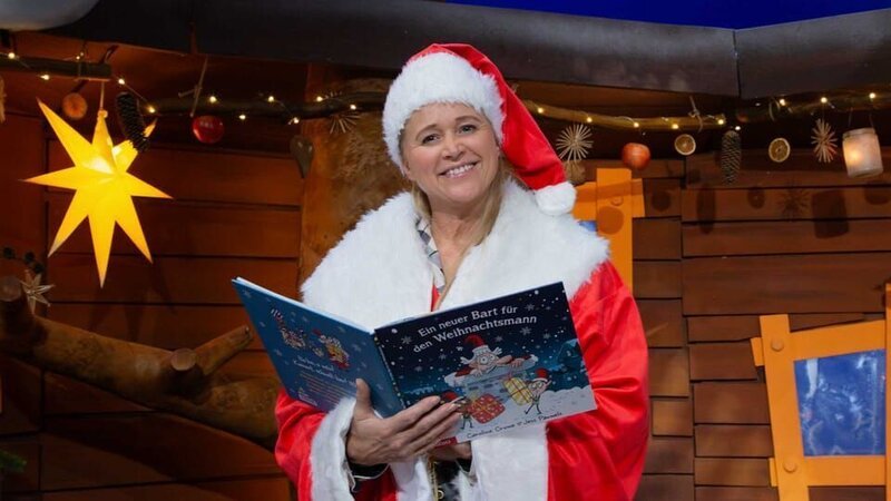 Singa stellt ein Buch aus der Vorlesezeit vor. In dem Buch verliert der Weihnachtsmann seinen Bart. Ob er ihn wiederfinden kann? – Bild: KiKA