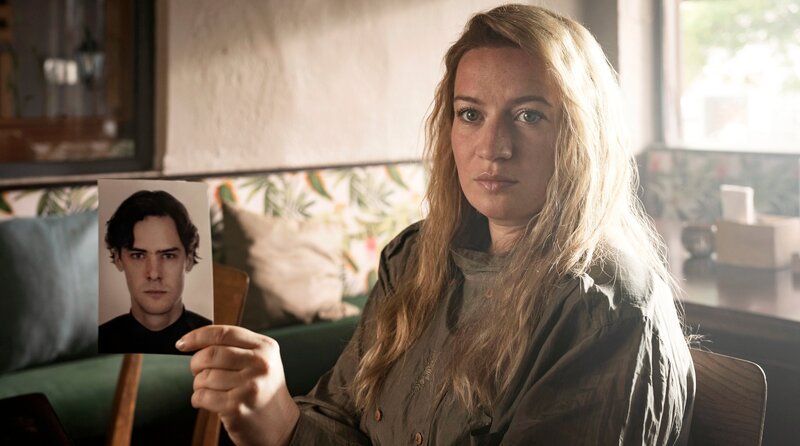 Kommissarin Rita Berg (Nina Gummich) zeigt der Zeugin Charlene ein Foto. – Bild: ARD Degeto Film/​BR/​Westside Filmproduktion GmbH/​Joe Alblas