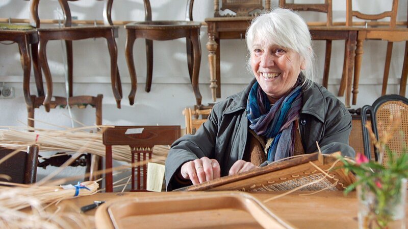 In einer ehemaligen Scheune restauriert Brigitte Meffert Stühle. – Bild: BR